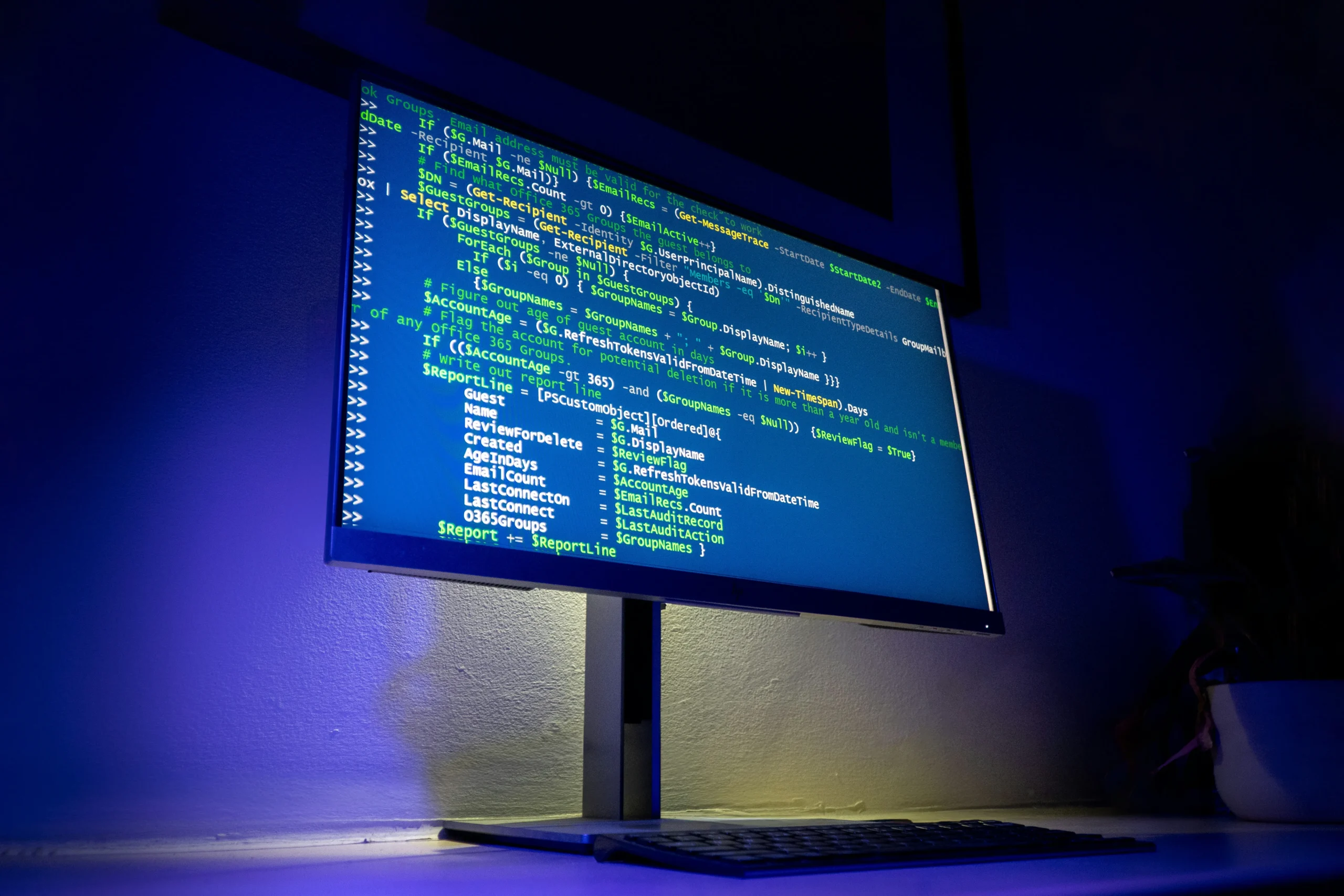 Un écran d'ordinateur allumé dans la pénombre affichant de nombreuses lignes de code informatique.
