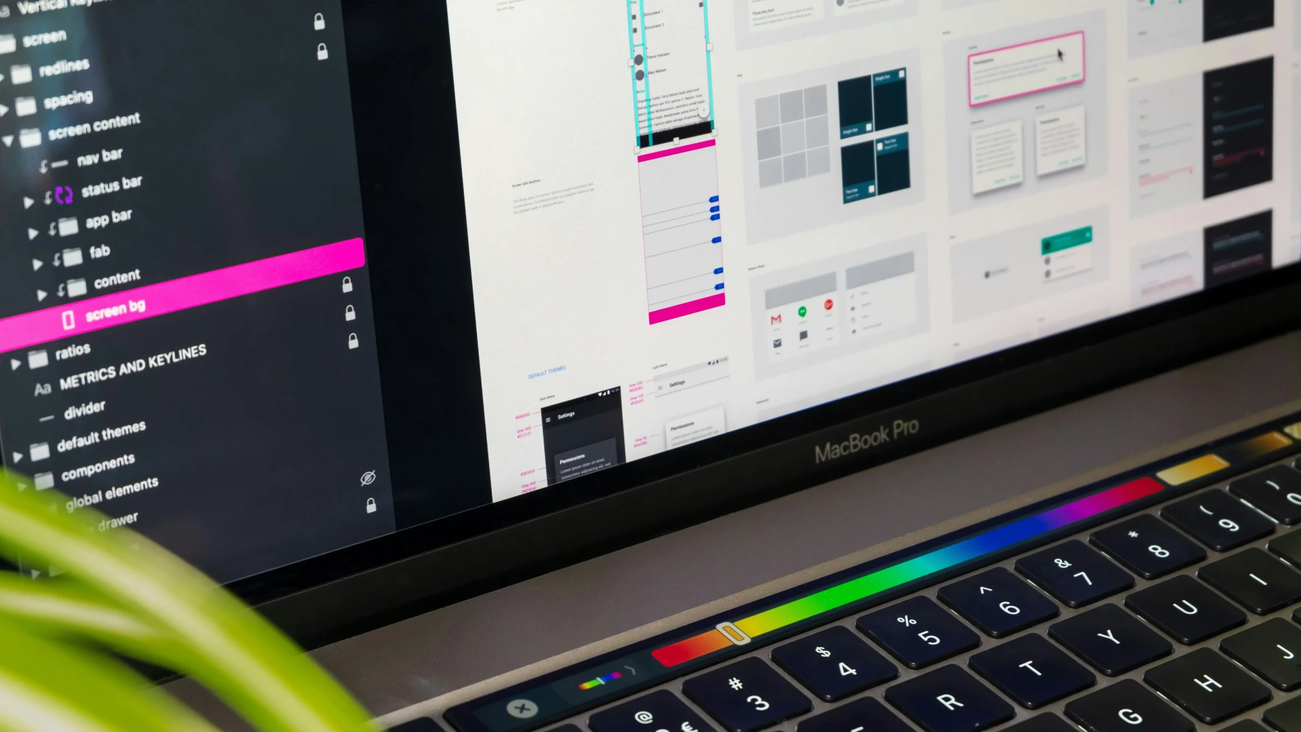 Gros plan sur l'écran d'un MacBook Pro affichant un logiciel de conception d'interface utilisateur et de maquettage.