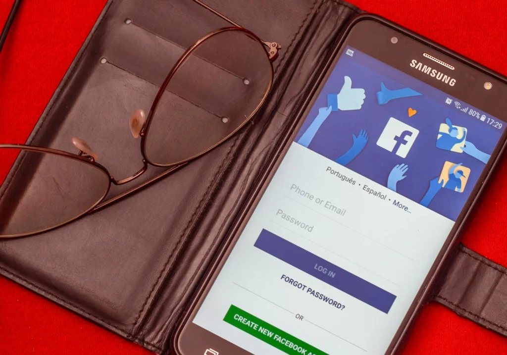 Vue rapprochée d'un smartphone. L'écran affiche la page d'identification de Facebook.
